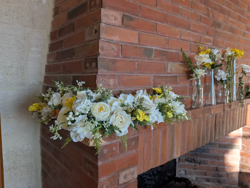 Classic mantelpiece floral decoration with white roses, chrysanthemums and berries for Wedding Fair 2025.